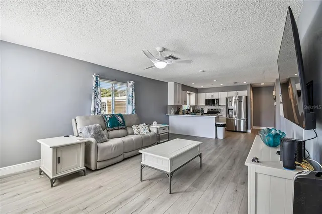 a living room with furniture a large window and a flat screen tv