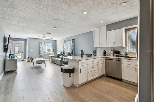 a open kitchen with white cabinets and white appliances