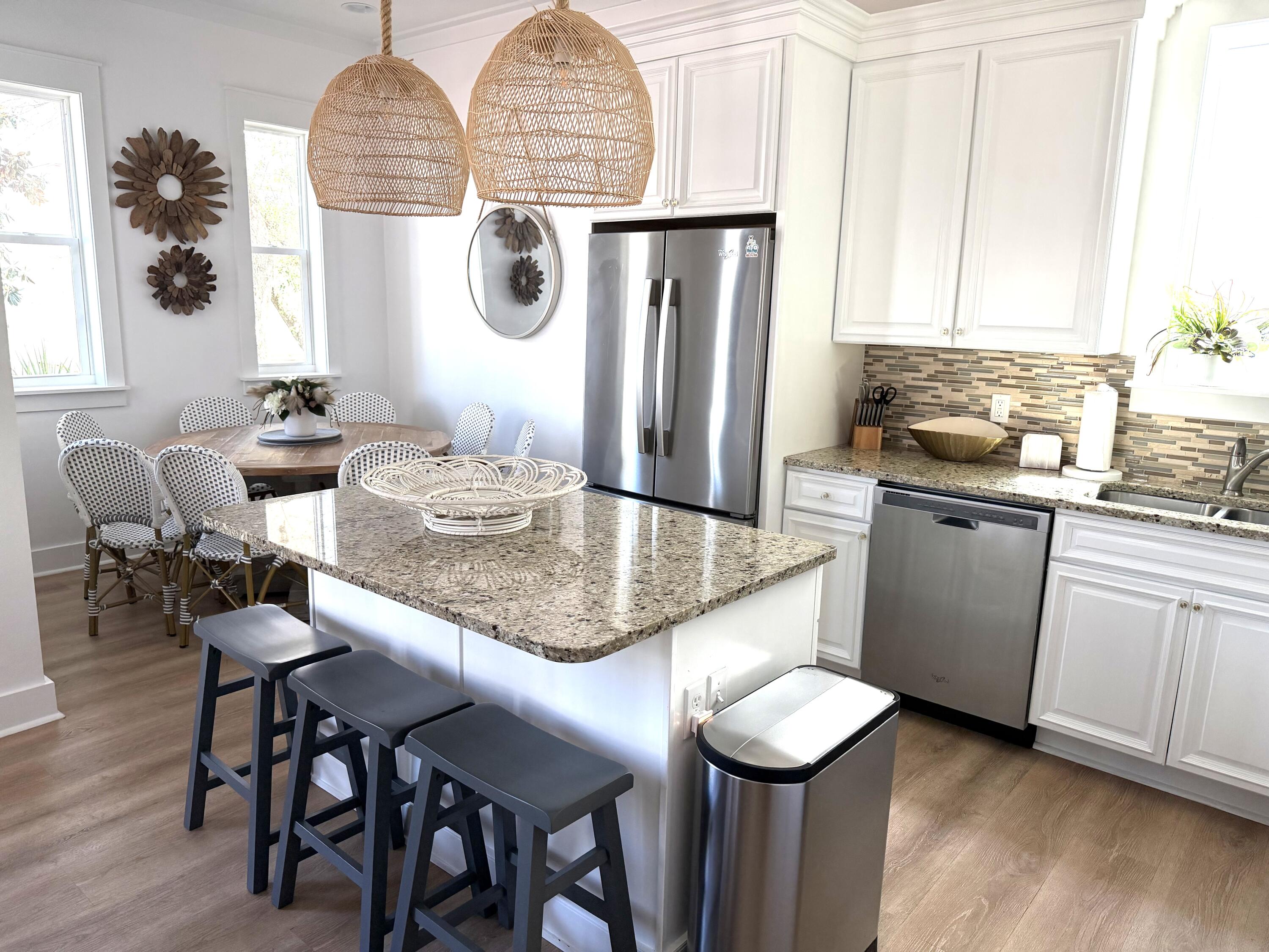 36 Moonlight Beach Lane Inlet Beach, FL 32461 - Photo 12 of 60 a kitchen with stainless steel appliances granite countertop a table chairs in it and wooden floors