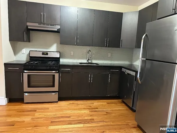 a kitchen with stainless steel appliances granite countertop a stove a refrigerator and a sink