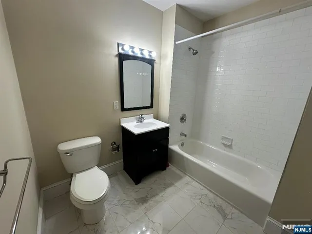 a bathroom with a bathtub sink mirror and toilet