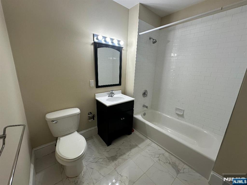 13-23 River Road, Unit 206 Fair Lawn, NJ 07410 - Photo 4 of 6 a bathroom with a bathtub sink mirror and toilet