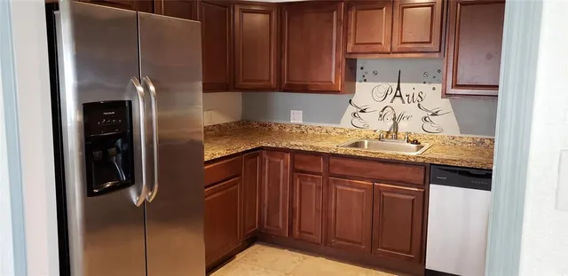 a kitchen with stainless steel appliances granite countertop a refrigerator and a sink