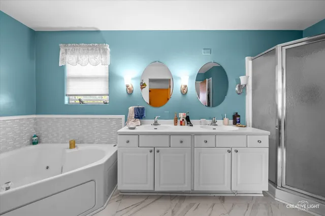 a bathroom with a tub sink and mirror
