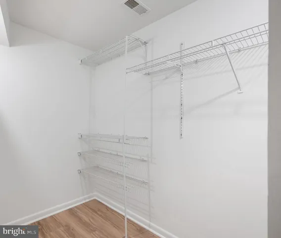 a view of a room that has wooden floor and white walls