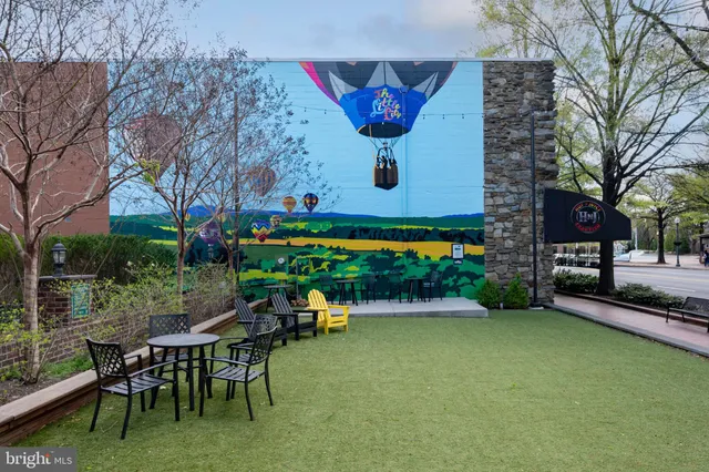 a view of a chairs and table in backyard of a house