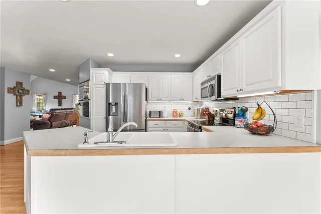 a kitchen with granite countertop stainless steel appliances a refrigerator a stove top oven and a refrigerator