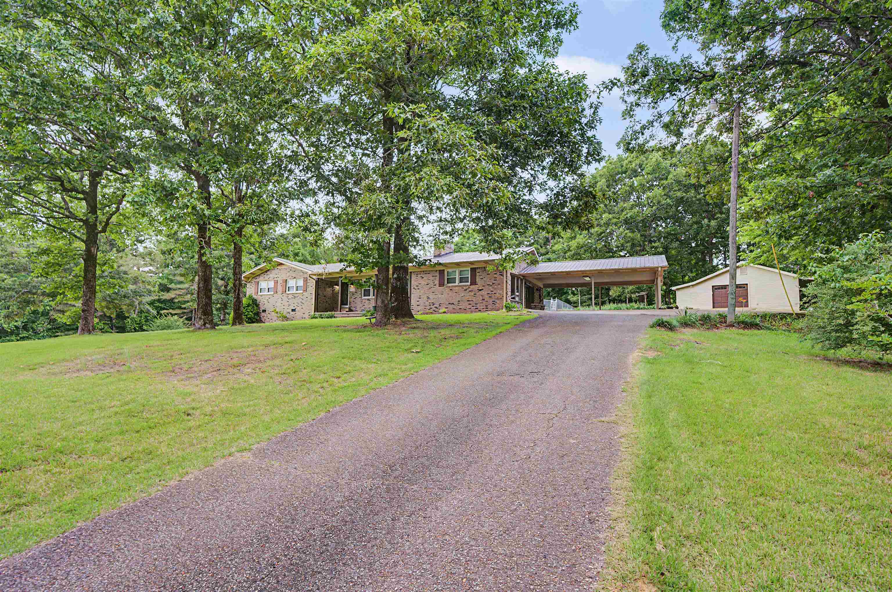 436 Skyline Road Selmer, TN 38375 - Photo 6 of 40 Paved driveway approaching a brick exterior residence with a multi-car carport