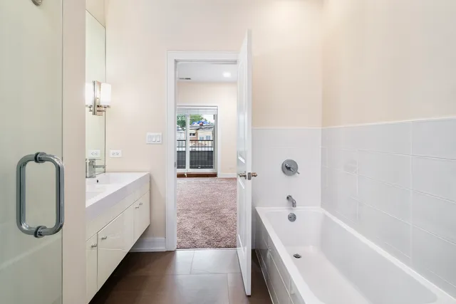 a bathroom with a tub sink mirror and a shower