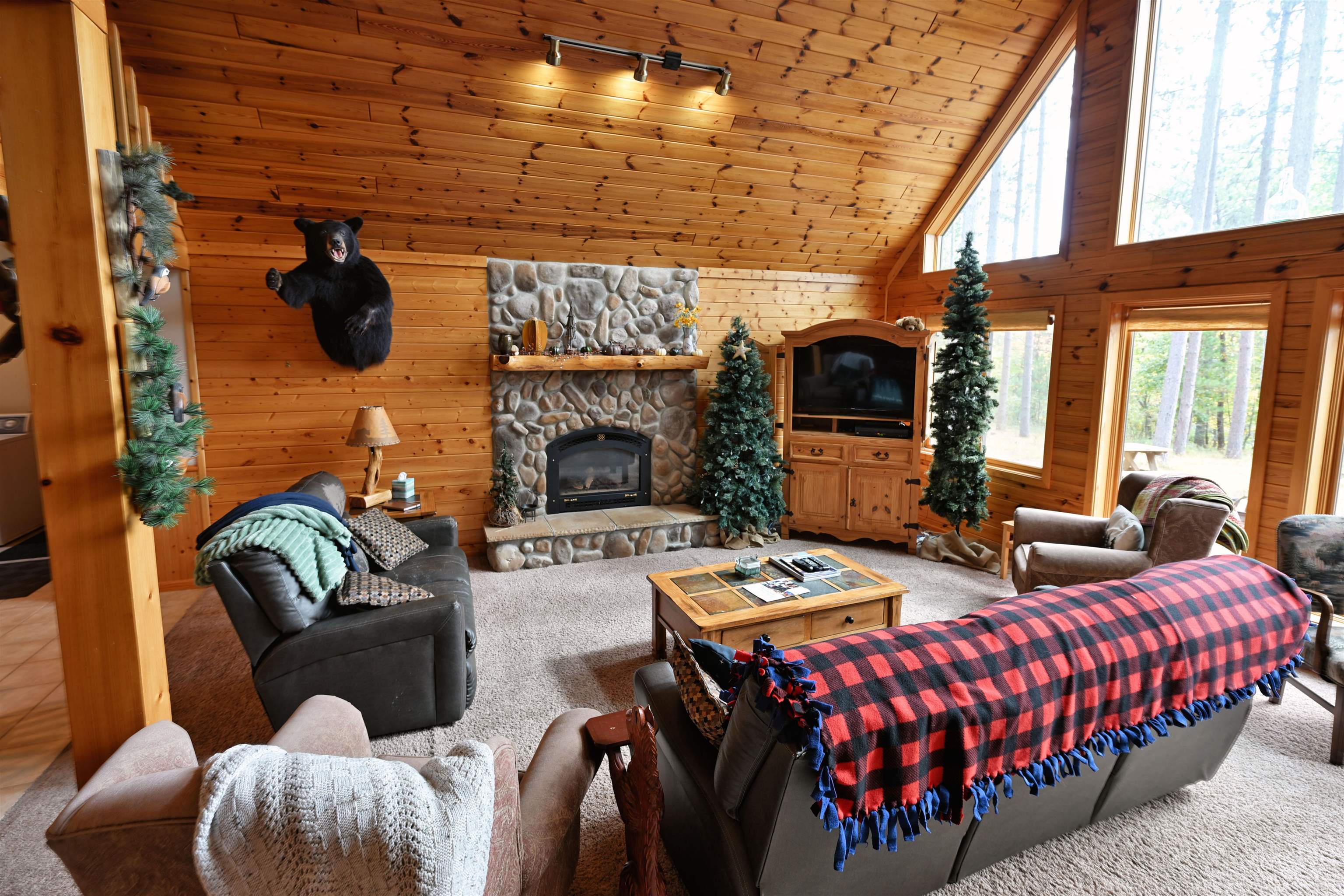 13672 East Short Road Gordon, WI 54838 - Photo 52 of 75 Carpeted living area with wooden walls, high vaulted ceiling, rail lighting, a stone fireplace, and wooden ceiling