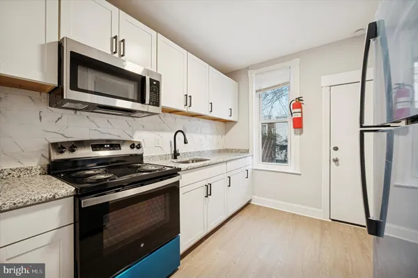 a kitchen with stainless steel appliances granite countertop a refrigerator stove and microwave