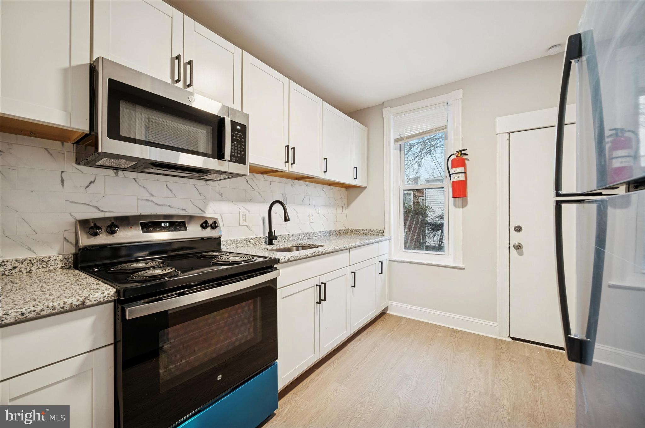 5517 Jane Street Philadelphia, PA 19138 - Photo 6 of 19 a kitchen with stainless steel appliances granite countertop a refrigerator stove and microwave