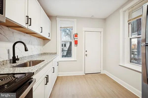 a kitchen with granite countertop a sink and a refrigerator