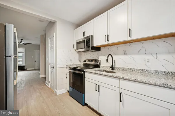 a kitchen with stainless steel appliances granite countertop a sink and a stove