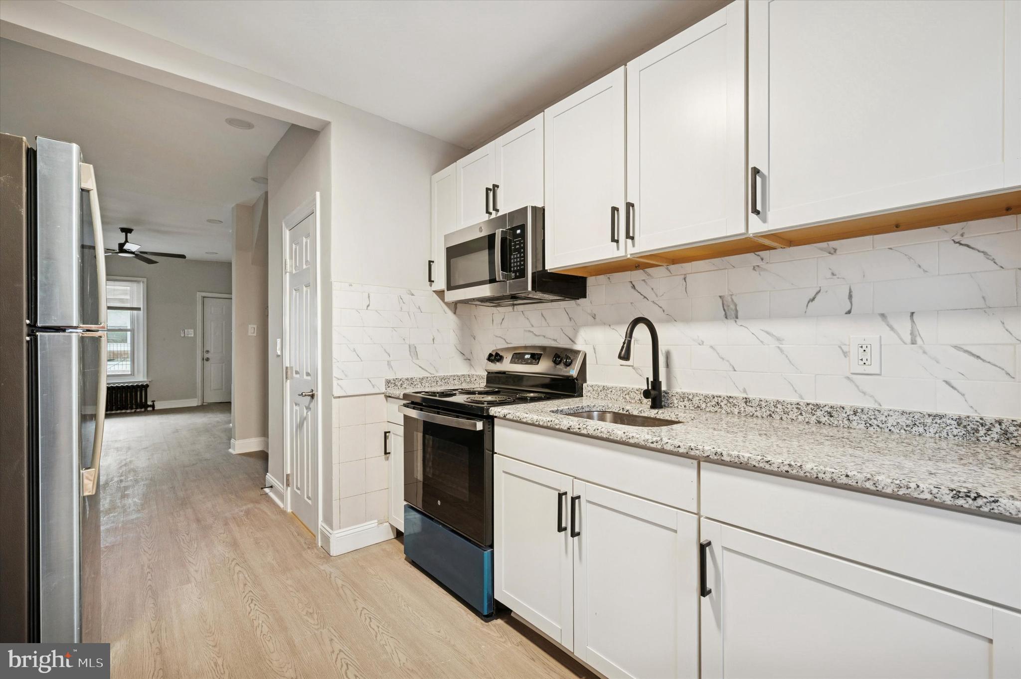 5517 Jane Street Philadelphia, PA 19138 - Photo 8 of 19 a kitchen with stainless steel appliances granite countertop a sink and a stove