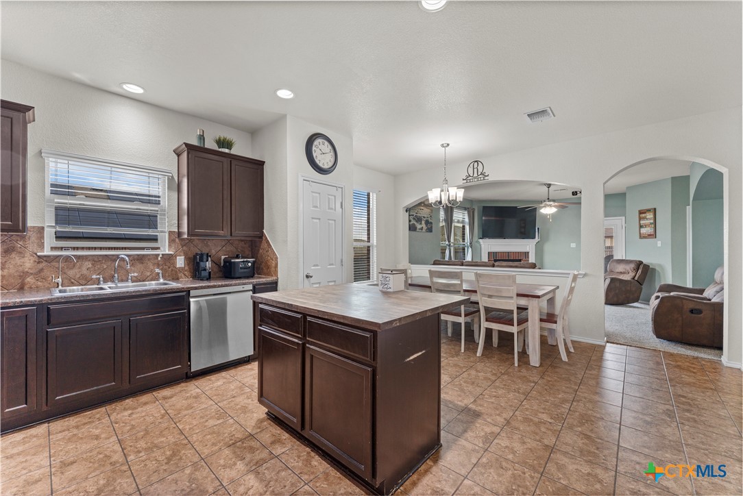 308 Kayla Street Troy, TX 76579 - Photo 17 of 32 a kitchen with stainless steel appliances granite countertop a stove top oven a sink dishwasher and a dining table with wooden floor