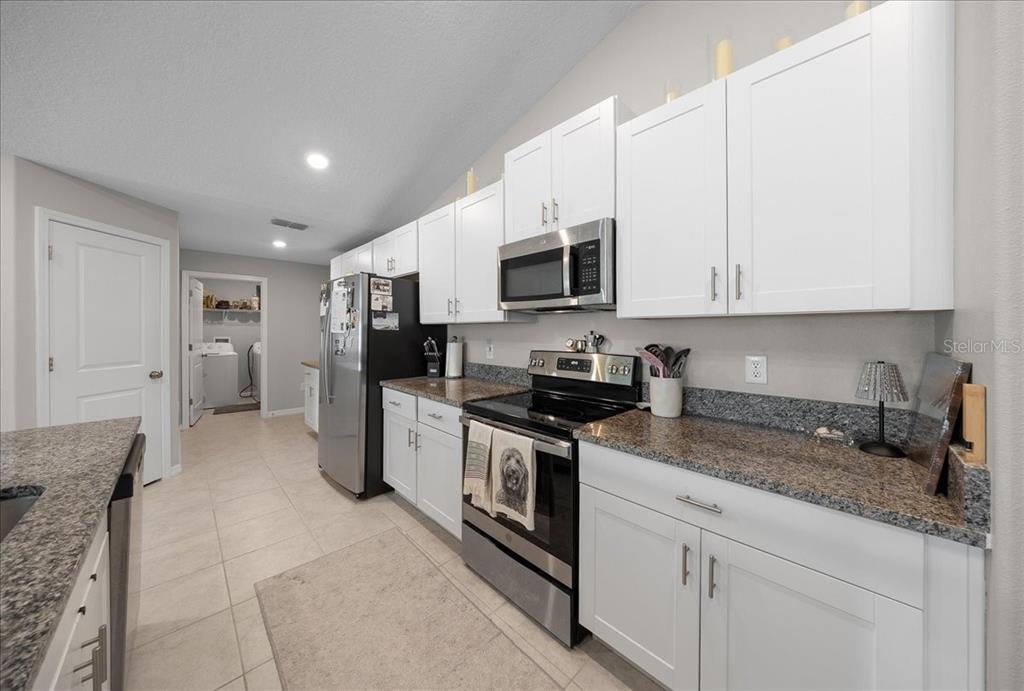 9329 Southwest 57th Terrace Ocala, FL 34476 - Photo 10 of 64 a kitchen with stainless steel appliances granite countertop a stove a sink and a refrigerator