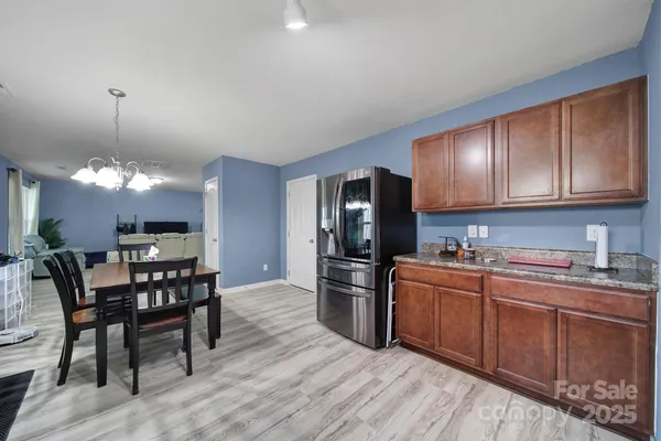 a kitchen with a dining table chairs and white cabinets