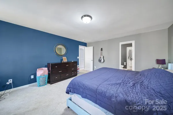 a bedroom with a bed and dresser with mirror