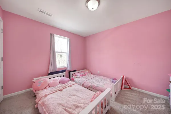 a bedroom with pink walls and pink bed