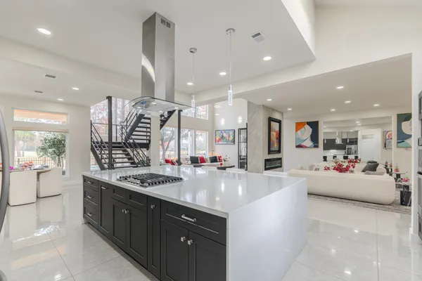 a large kitchen with stainless steel appliances a large counter top a stove and a sink