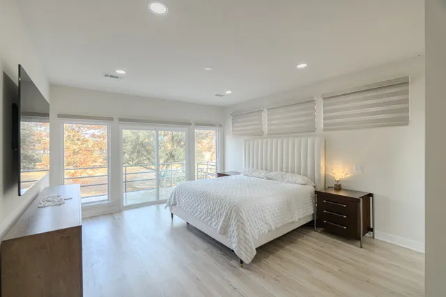 a large bedroom with a bed and wooden floor