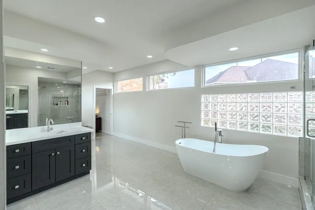 a large spacious bathroom with a double vanity sink a mirror and a bathtub