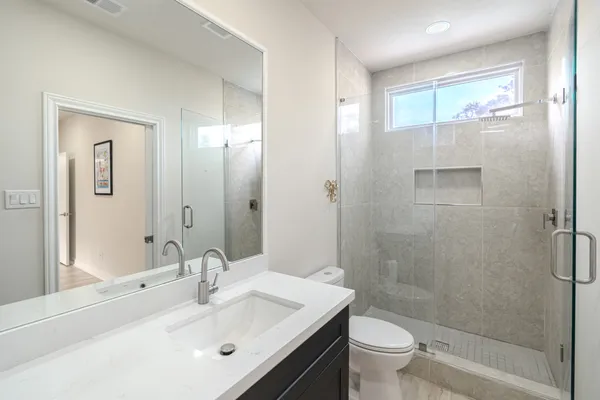 a bathroom with a sink a toilet and shower