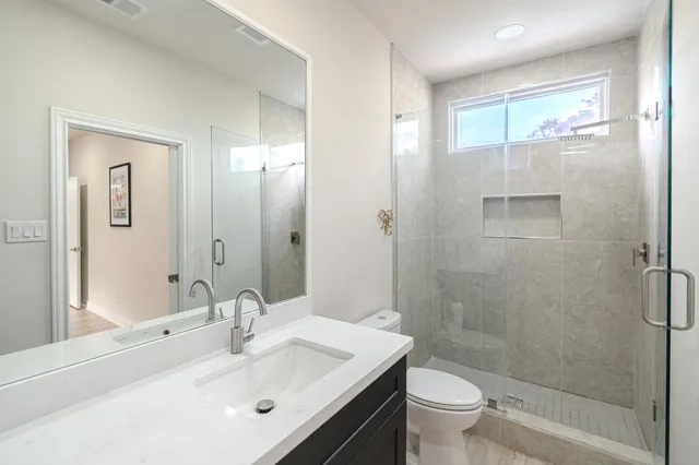 a bathroom with a sink a toilet and shower