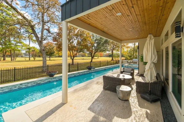 a patio with table and chairs and garden
