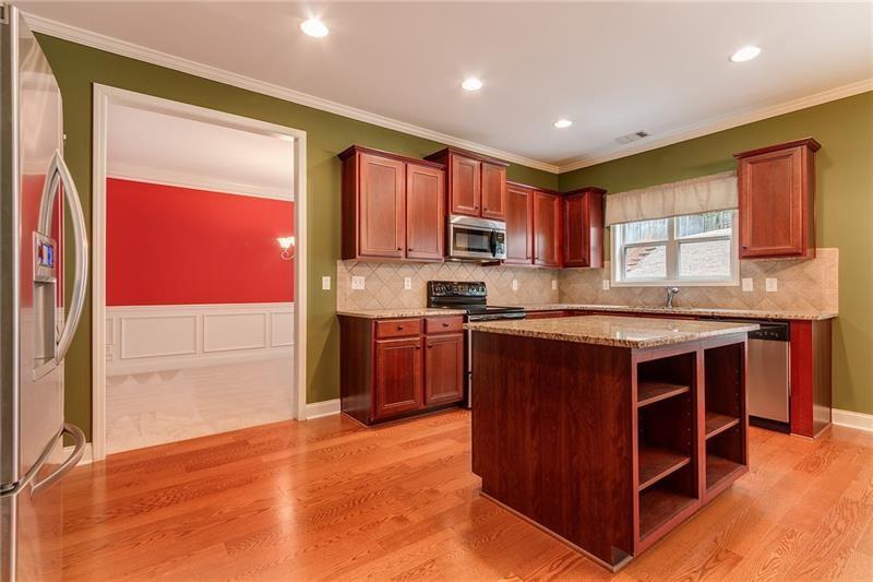 3590 Falling Leaf Lane Cumming, GA 30041 - Photo 18 of 37 a kitchen with stainless steel appliances granite countertop a stove a sink and a refrigerator with wooden cabinets