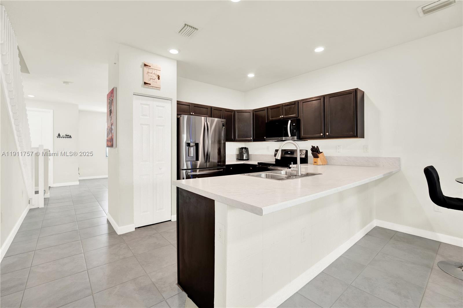 11411 Southwest 248th Lane Homestead, FL 33032 - Photo 12 of 40 a kitchen with stainless steel appliances a refrigerator sink and microwave