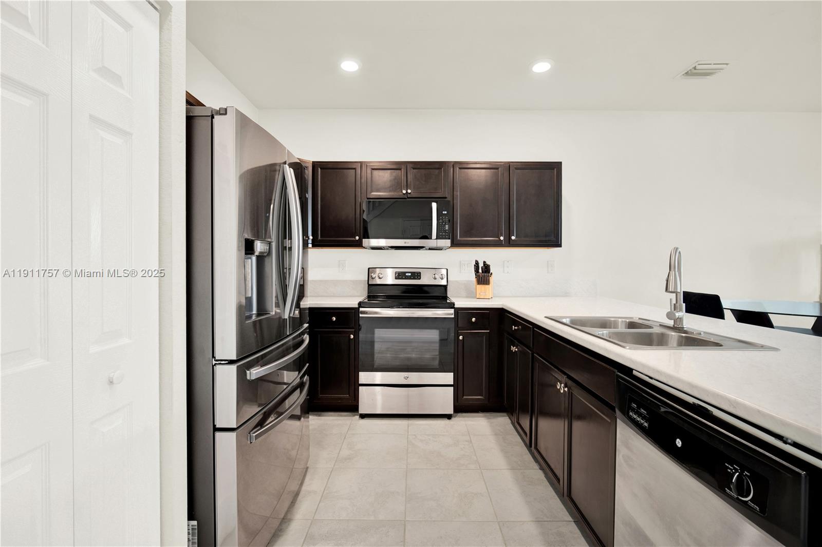 11411 Southwest 248th Lane Homestead, FL 33032 - Photo 13 of 40 a kitchen with a refrigerator and a stove top oven