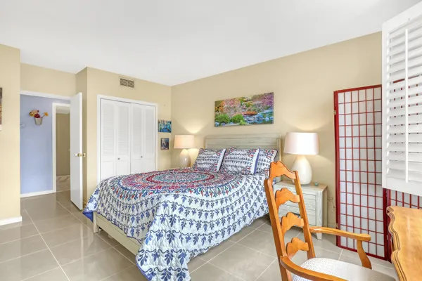 a bedroom with a bed and painting on the wall