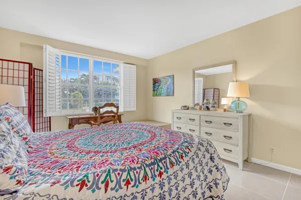a bedroom with a bed and a dresser next to a window