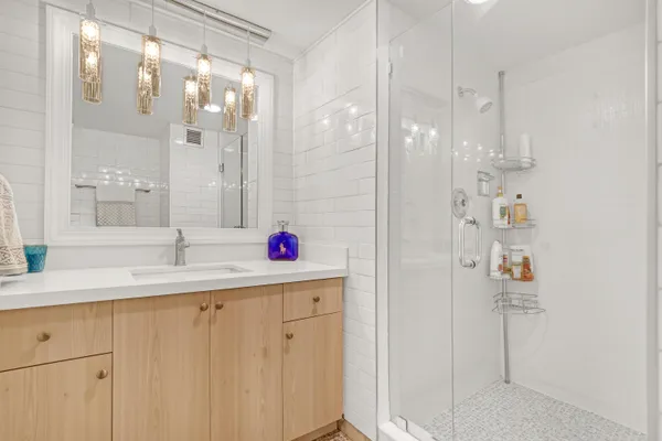 a bathroom with a shower sink and mirror