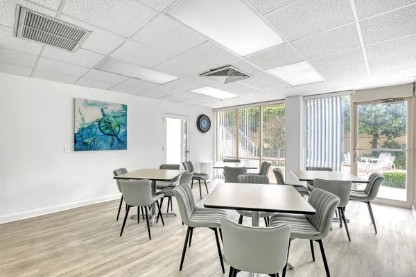 a dining room with furniture a large window and wooden floor