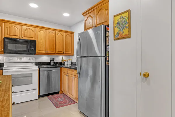 a kitchen with stainless steel appliances granite countertop a refrigerator and a stove top oven