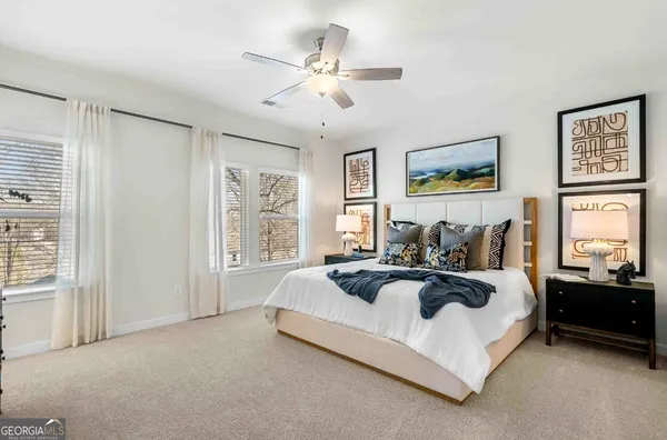 a spacious bedroom with a bed a couch and large window