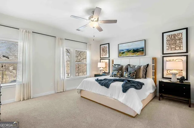 a spacious bedroom with a bed a couch and large window