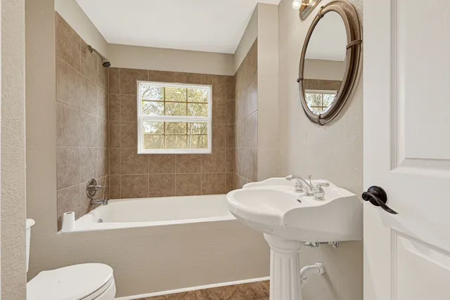 a bathroom with a sink mirror bathtub and toilet