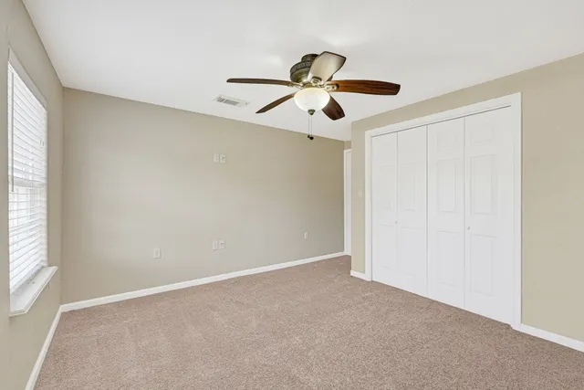a view of a room with a ceiling fan and a window