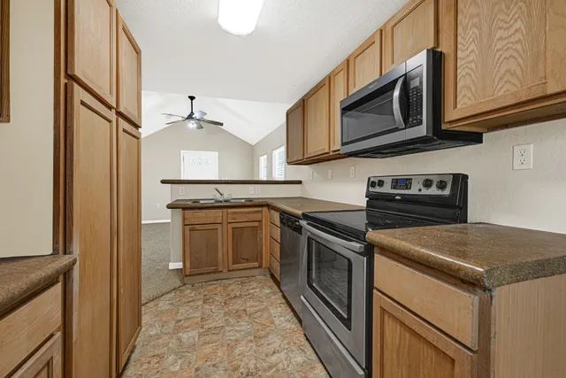 a kitchen with stainless steel appliances granite countertop a stove microwave and refrigerator