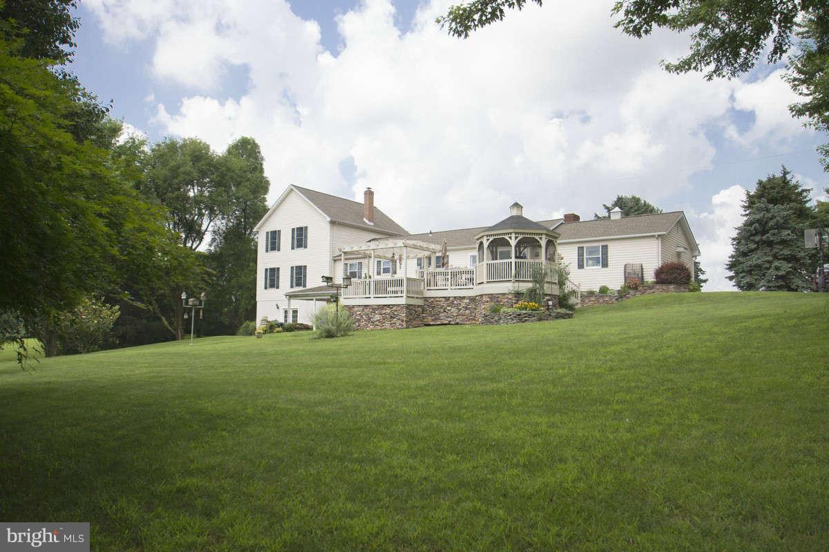 21107 Gunpowder Road Manchester, MD 21102 - Photo 29 of 30 a view of a white house in front of a big yard with plants and large trees