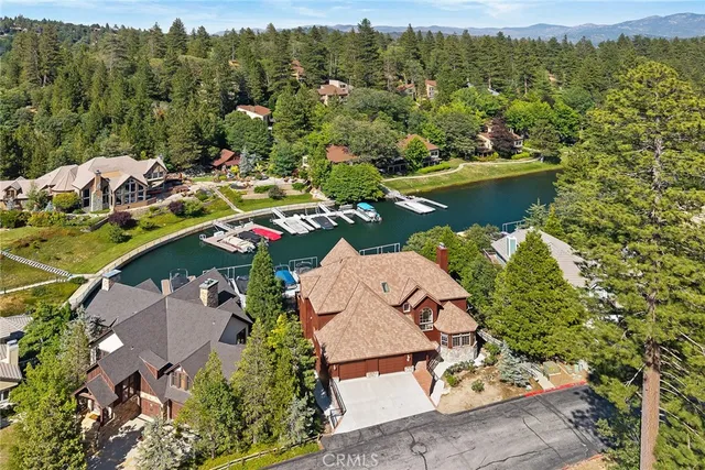 an aerial view of a house with swimming pool and lake view