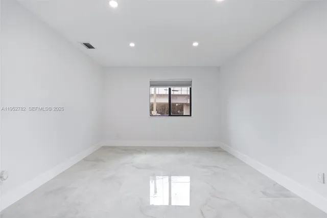 a kitchen with white cabinets and sink