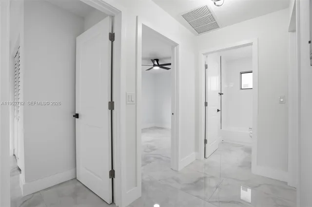 a white house that has tree in front of it