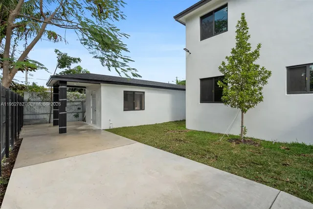 an aerial view of residential houses with outdoor space and trees