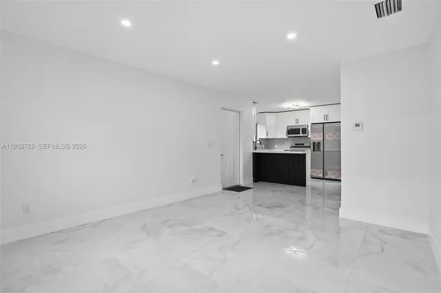 a view of a kitchen with a sink and a refrigerator