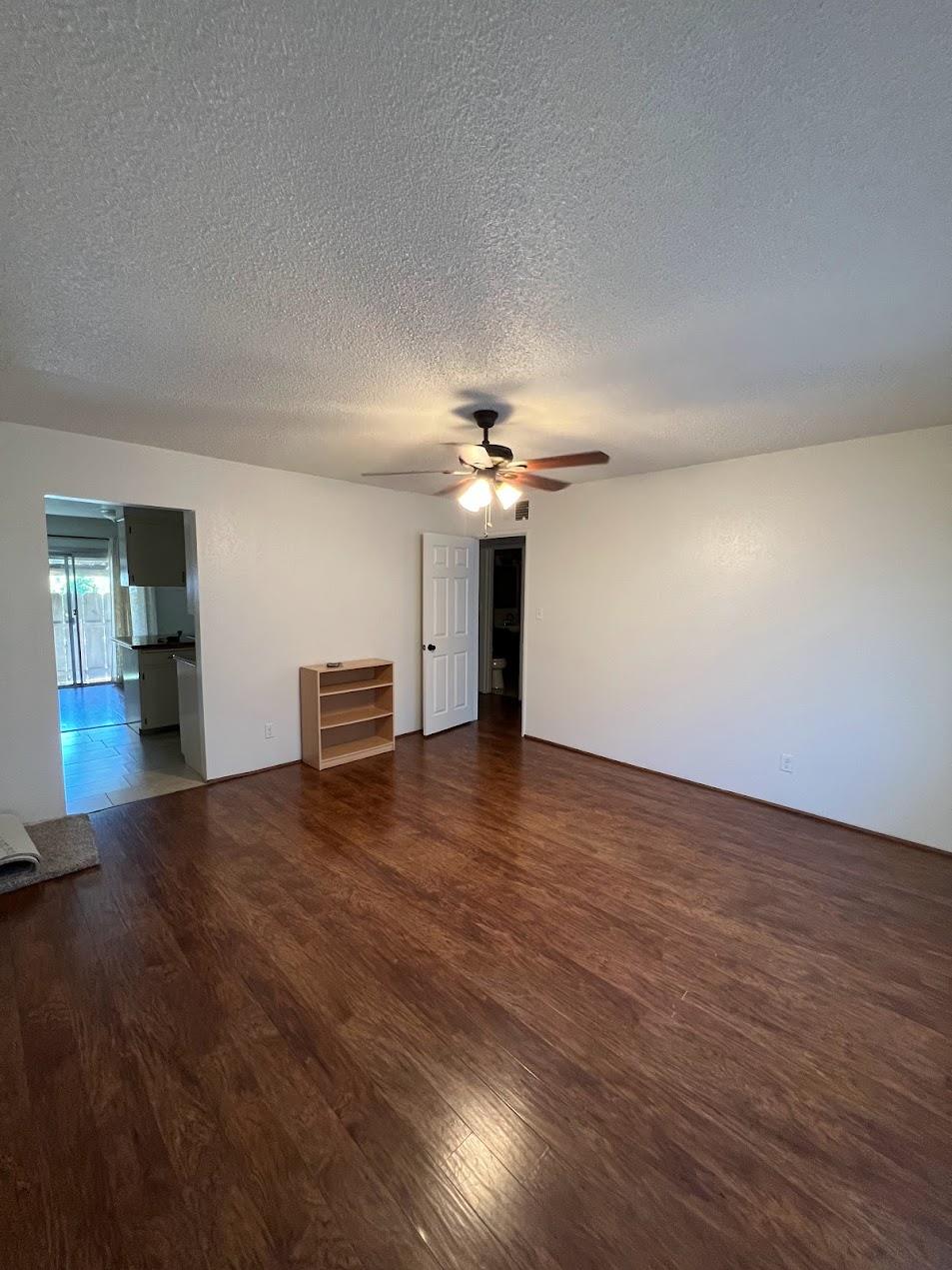 1205 F Street Reedley, CA 93654 - Photo 11 of 34 a view of a livingroom with wooden floor and ceiling fan